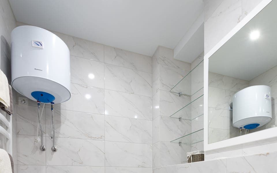 Wall-mounted geyser in a tiled bathroom